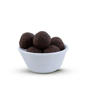 A bowl filled with round millet snacks, with a predominantly white background.